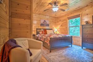 Schlafzimmer mit einem Bett und einem Deckenventilator in der Unterkunft Cozy Cabin Living by Lake Chatuge with Covered Patio in Hiawassee