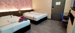 a hotel room with two beds with flowers on them at Smile Hotel Cheras Pudu KL in Kuala Lumpur