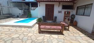 a house with a pool and a bench next to it at Casa Temporada Vila Residencial Furnas, Capitólio MG in Furnas