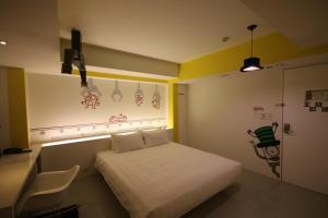 a small room with a bed and a chair at Hotel Papa Whale-Kaohsiung Formosa Boulevard in Kaohsiung