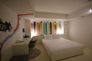 1 dormitorio con cama, escritorio y ventana en Hotel Papa Whale-Kaohsiung Formosa Boulevard, en Kaohsiung