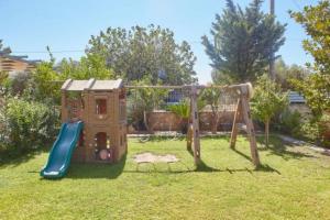 un parque infantil con un tobogán en un patio en Harmony Vale, en Anavyssos
