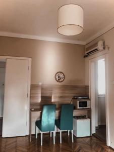 a kitchen with two chairs and a table and a clock at Apartman Tara in Belgrade
