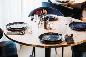 une table avec des assiettes noires et des fleurs sur elle dans l'établissement Boutique Hotel Lupo, à Flessingue