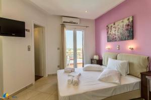 アギアアンナ・ナクソスにあるNaxos Mareの紫の壁のベッドルーム1室(白い大型ベッド1台付)
