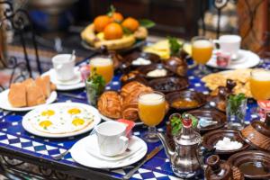 a breakfast table with eggs and bread and orange juice at Riad Fes Aicha & SPA in Fez