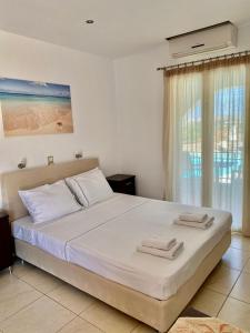 a bedroom with a large bed with towels on it at Naxos Mare in Agia Anna Naxos
