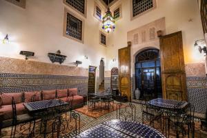 a living room with a couch and some tables at Riad Fes Aicha & SPA in Fez