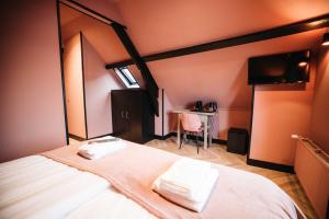 een slaapkamer met een bed met twee handdoeken erop bij Boutique Hotel Lupo in Vlissingen