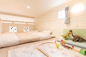 The Guest Villa 箱根湯本 V-II في هاكوني: غرفة نوم فيها سرير و فيها قطار العاب