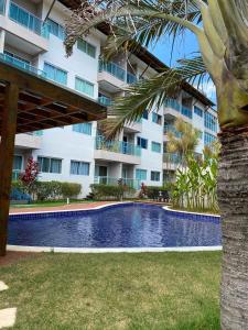 a swimming pool in front of a building at Porto Plaza Flat Service Apt 309 in Porto De Galinhas