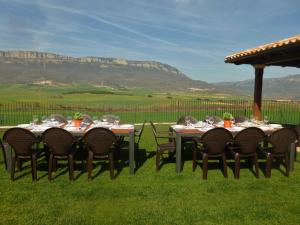 a group of tables and chairs with mountains in the background at Casa rural Navarra para niños, accesible para grupos grandes de 14-16 personas Belastegui II in Eulz