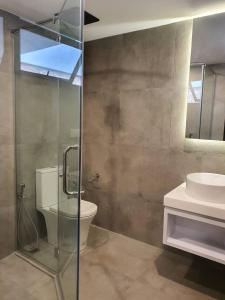 a bathroom with a glass shower and a toilet at Luxurious Georgetown Townhouse in Core Zone in George Town