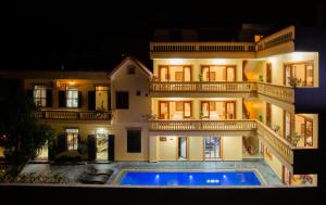 a large house with a swimming pool in front of it at Lys Homestay in Ninh Binh