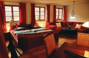 sala de estar con sofá y sala de estar con cortinas rojas. en Wampendobler Paradies en Egglham