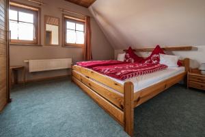 a bedroom with a large wooden bed with red pillows at Ferienhäuser zur Schäferei in Mitwitz