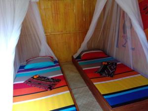 two bunk beds in a room with white curtains at Sten Lodge eco Homestay in Labuan Bajo