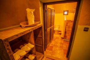 La salle de bains est pourvue de toilettes et d'une étagère avec des serviettes. dans l'établissement Takojt, à Merzouga