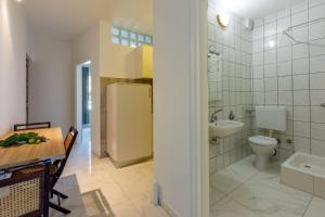 uma casa de banho com um WC, um lavatório e um frigorífico em Apartment Goran em Crikvenica