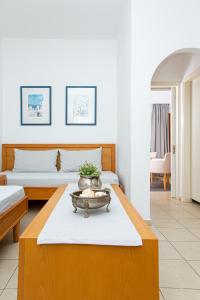 a living room with two beds and a table at Villa Mare Monte ApartHotel in Malia