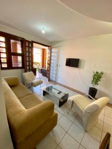 un soggiorno con divano e tavolo di Linda casa Porto das Dunas: 4 suítes, churrasqueira e piscina a Fortaleza