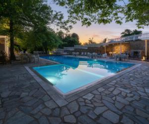 a large swimming pool with a stone walkway around it at Κonitsa Gefyri hotel in Konitsa