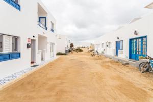 an empty dirt road between white buildings at El Sombrerito 5 in Caleta de Sebo +13 photos