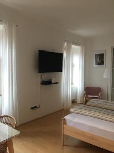 a bedroom with a bed and a flat screen tv at Gábriel Apartman in Kőszeg