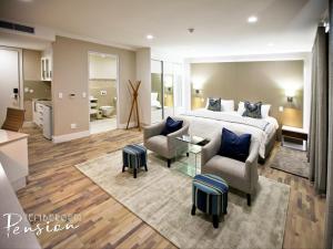 een grote slaapkamer met een bed en een woonkamer bij Tenbergen Pension Hotel in Windhoek