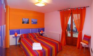 1 dormitorio con 1 cama de color naranja y azul en Casa rural Navarra cerca del nacedero del Urederra Belastegui, en Eulz