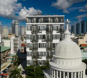 um edifício branco alto com uma cúpula branca em frente em KunKin Luxury Hotel & Apartment em Ho Chi Minh