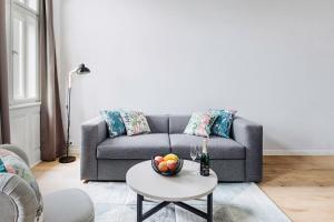 a living room with a couch and a table with a bowl of fruit at Franz BY ZEITRAUM in Prague