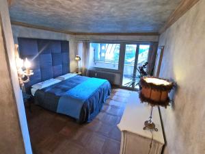 ein Schlafzimmer mit einem blauen Bett und einem Fenster in der Unterkunft Beautiful apartment over the mountain in Crans-Montana