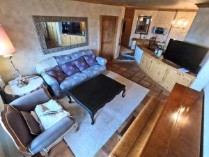 einen Blick über ein Wohnzimmer mit einem Ledersofa in der Unterkunft Beautiful apartment over the mountain in Crans-Montana