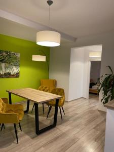 comedor con mesa y sillas amarillas en Apartamente Bucegi, en Râșnov