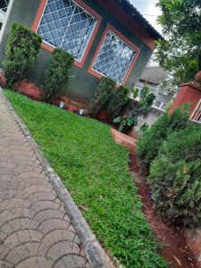 a house with a green lawn in front of it at Claire's Haven in Nairobi