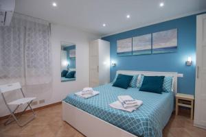 een blauwe slaapkamer met een bed met handdoeken erop bij Ncantu home in Palermo