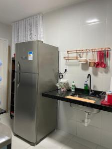 cocina con nevera de acero inoxidable y encimera en Apartamento Mobiliado Temporada, en Fortaleza