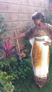 a woman in a dress standing in a garden at Claire's Haven in Nairobi