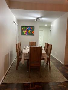 una mesa de comedor con sillas y una pintura en la pared en Apartamento Mobiliado Temporada, en Fortaleza