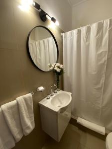 Baño blanco con lavabo y espejo en Gran Hotel Panamericano en Mar del Plata