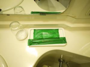 a table with a green bag and glasses on a plane at Hotel Route-Inn Kitakyushu-Wakamatsu Ekihigashi in Kitakyushu