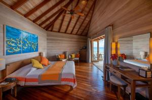 A bed or beds in a room at Mirihi Island Resort