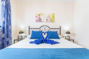 ein Schlafzimmer mit einem Bett mit blauen Kissen in der Unterkunft El Sombrerito 5 in Caleta de Sebo