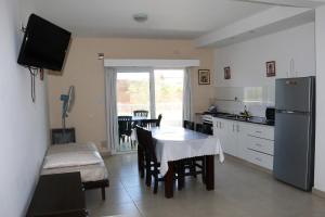a kitchen with a table and a dining room at Departamentos LG in Las Grutas