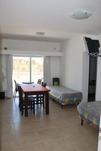 a room with a table and a bed and a table and chairs at Departamentos LG in Las Grutas +9 photos