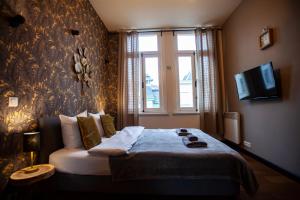 una camera con un letto, una finestra e una TV di Luxury Suits Historic Center ad Anversa
