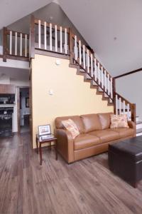 
a living room filled with furniture and a staircase at Bambury's Hillside Chalets in Rocky Harbour
