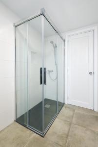 cabina de ducha de cristal en una habitación con puerta en Apartamentos Playamar, en Puerto del Carmen