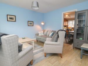 a living room with two chairs and a couch and a table at Armstrong Cottage in Beverley